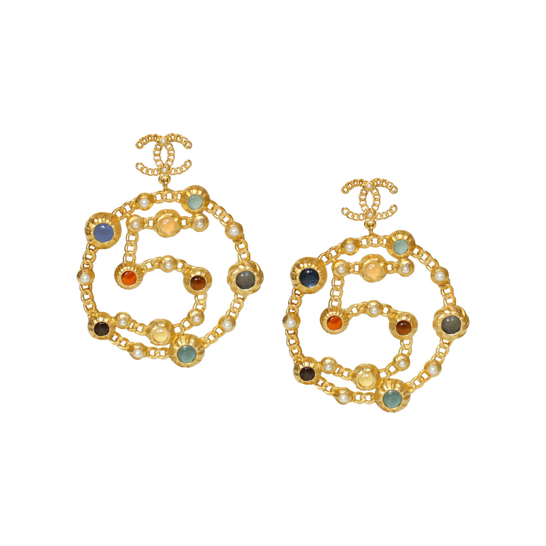 A pair of Chanel dangle earrings with gold frames and multicolored stone inlays in the shape of a circle, from the 2018 Runway collection.