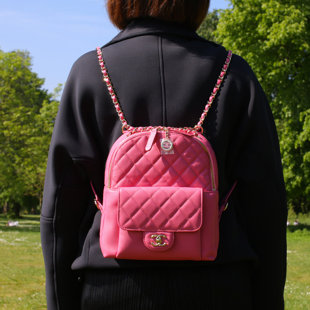Model carrying the backpack with its two interwoven leather and chain straps.