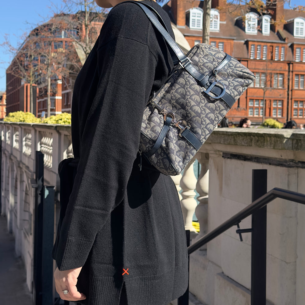 Model carrying a vintage Dior shoulder bag with blue oblique canvas.