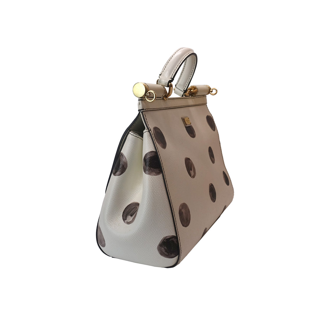 The handbag features a leather handle with gold-toned hardware links and leather anchors.