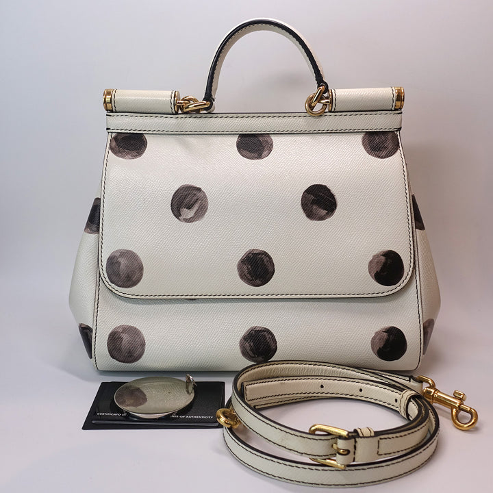 The handbag comes with a mirror, an adjustable and detachable strap, and cards.