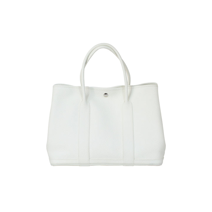 The handbag features two rolled leather handles.