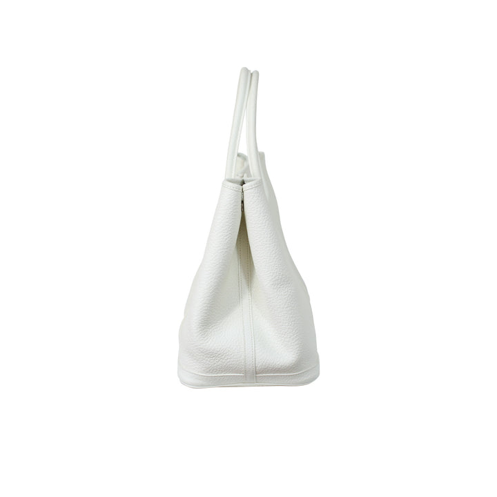 The side of the handbag features a snap button closure to fasten the bag.