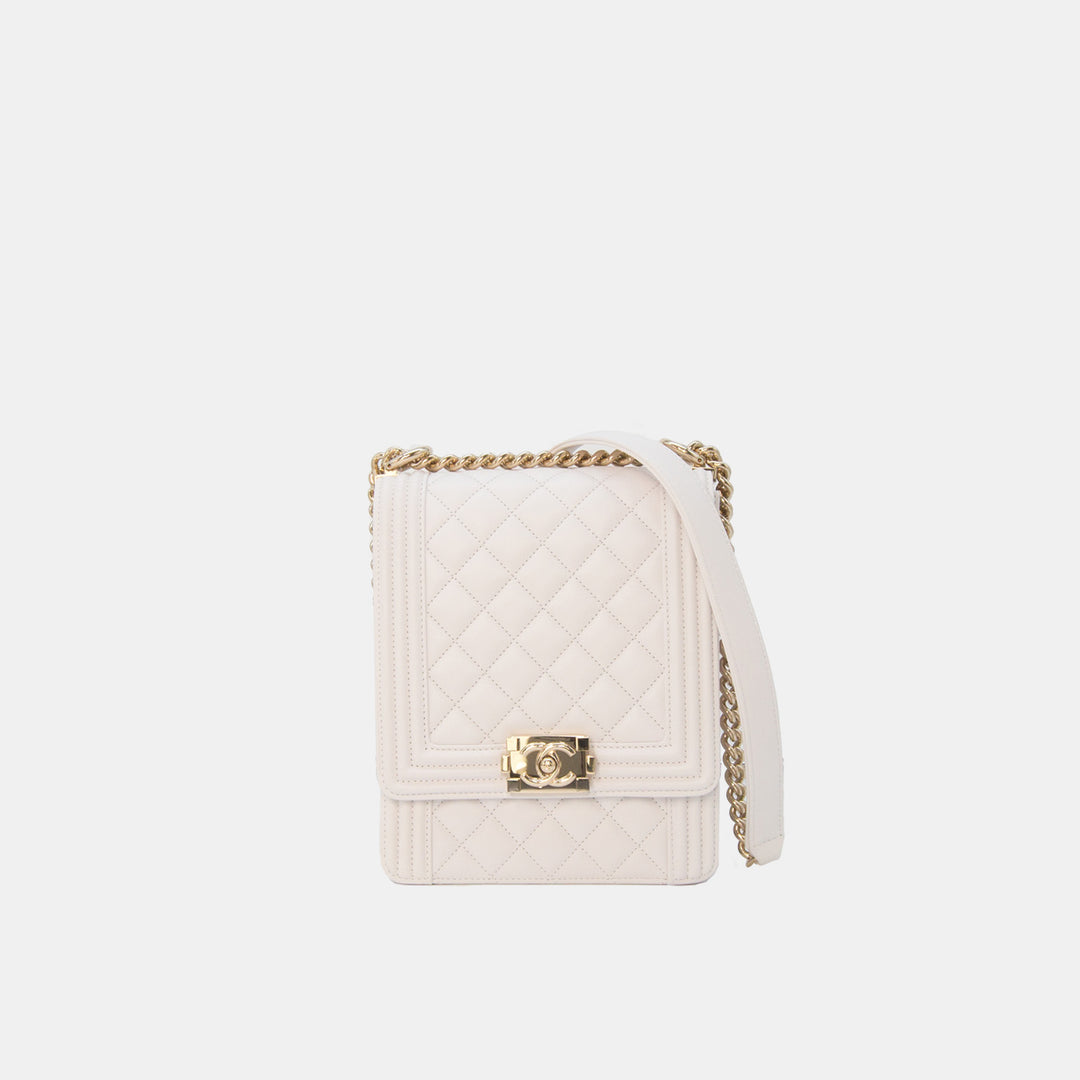 A white Chanel North South Boy Flap Bag with gold hardware and a quilted design, featuring a chain strap.