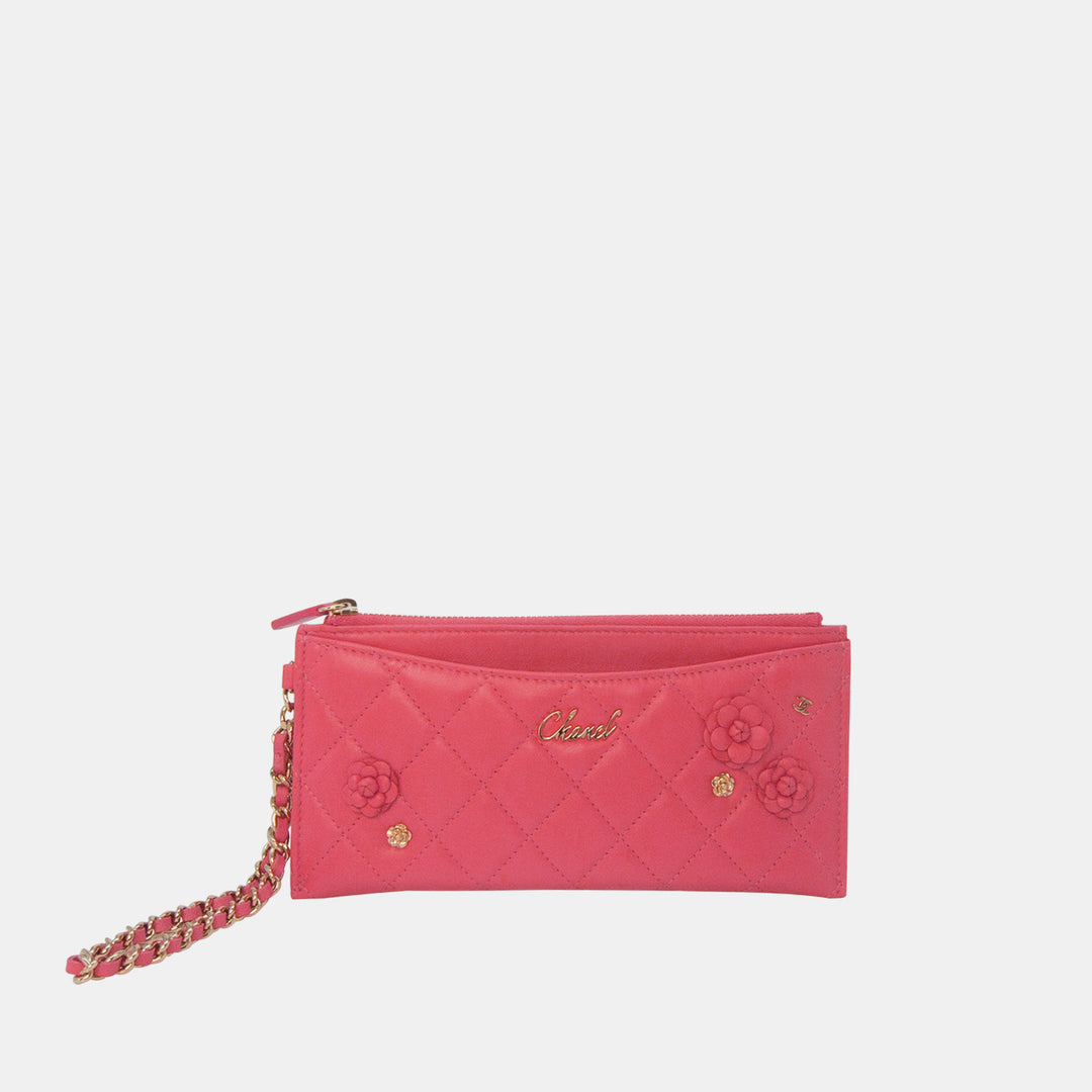 A pink Chanel Small Camellia CC Charm Wallet Clutch with gold hardware and a quilted lambskin design, featuring a chain strap.
