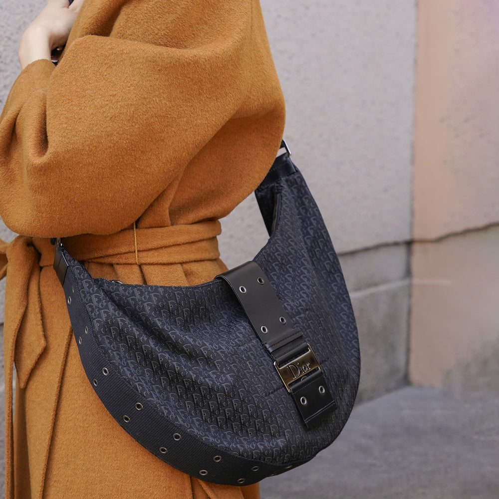 Model carrying the crossbody bag by its adjustable strap.