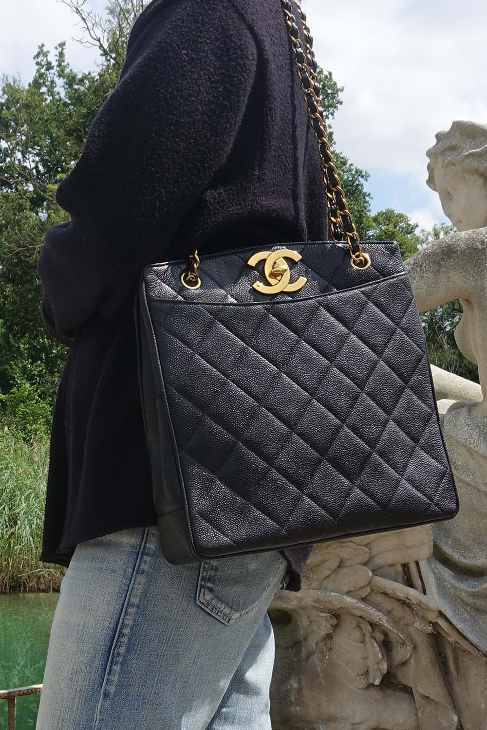 Model carrying the vintage Chanel caviar leather tote by its shoulder straps. 