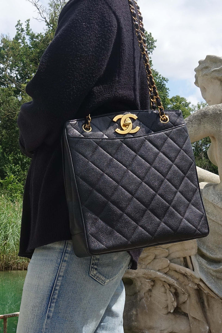 Model carrying the vintage Chanel caviar leather tote by its shoulder straps. 