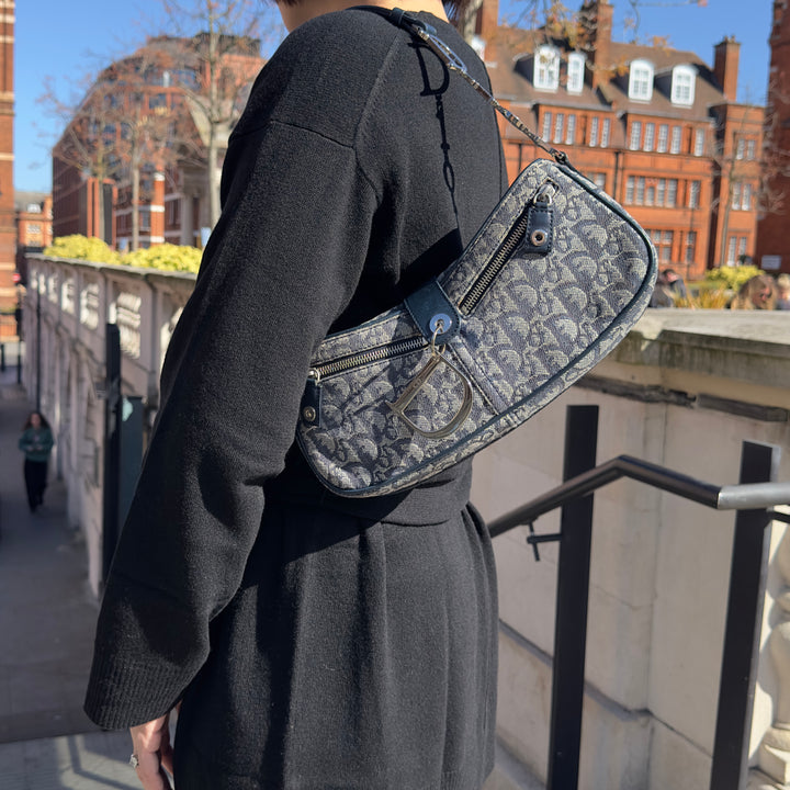 Model showing the Dior Vintage Oblique Trotter Baguette Bag with D Charm Navy Blue Canvas.
