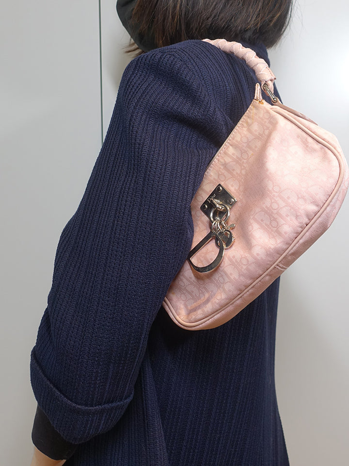 The model is carrying the vintage Dior Lovely shoulder bag with its unique rolled leather strap.