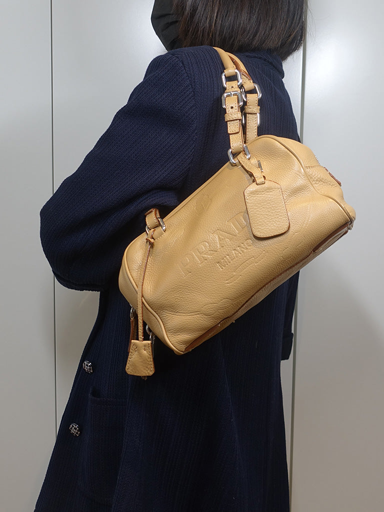 The model is carrying the vintage Prada shoulder bag with its two adjustable leather straps.